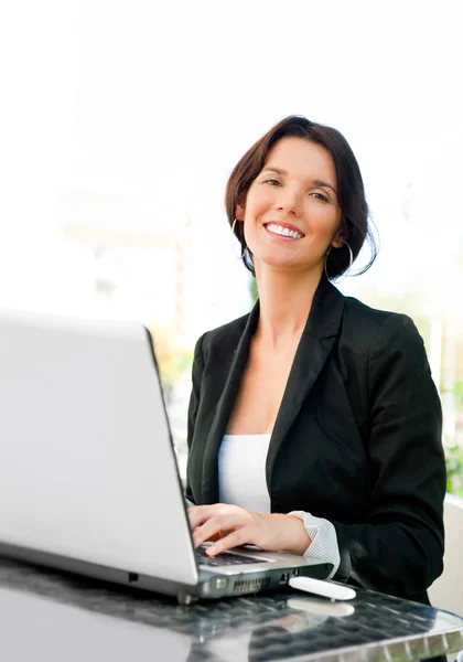 Jovem mulher de negócios em um laptop usando conexão à internet sem fio — Fotografia de Stock