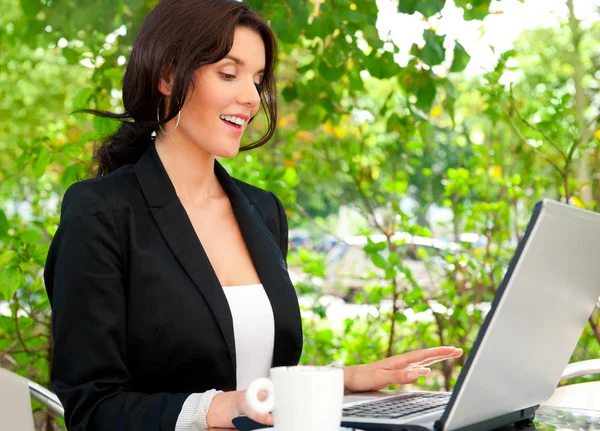 Portret van een jonge Glimlachende zakenvrouw met behulp van laptop op overtreffen — Stockfoto
