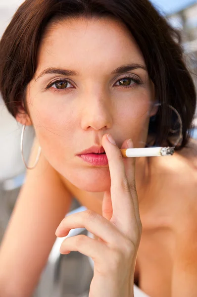 Porträt einer schönen Frau raucht draußen im Café eine Zigarette — Stockfoto
