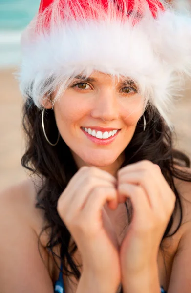 크리스마스 모자 보여주는 심장 모양 입고 젊은 아름 다운 여자 — 스톡 사진
