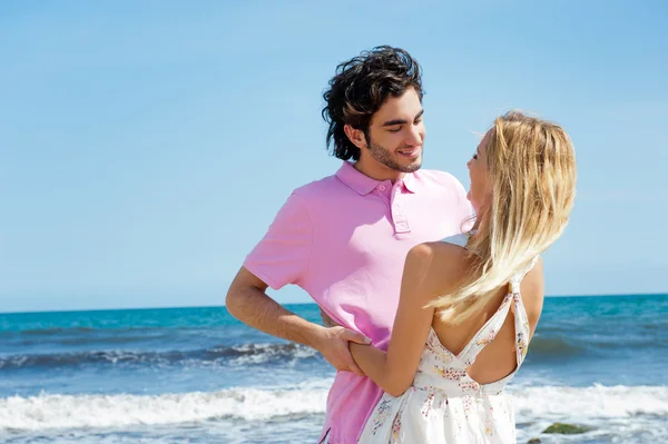 Mladý pár na pláži, všeobjímající, boční pohled. přirozené emoce. h — Stock fotografie