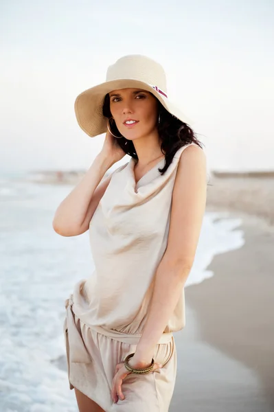 Sonriente mujer joven con un sombrero de paja y divertirse en el be — Foto de Stock