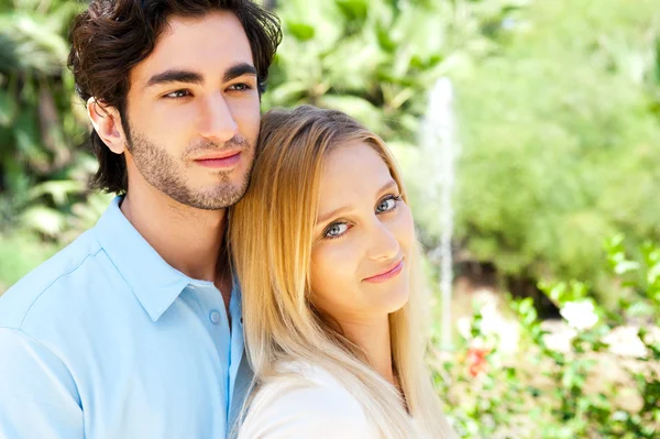 Portrait of love couple embracing outdoor in park looking happy — Stock Photo, Image