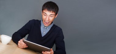 Closeup of a young smiling business man sitting at his office ag clipart