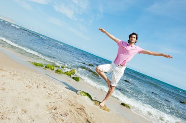 Portrait of young man standing carefree with outstretched arms o clipart