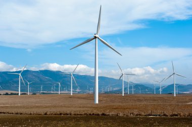 Wind power station - wind turbine against the blue sky clipart