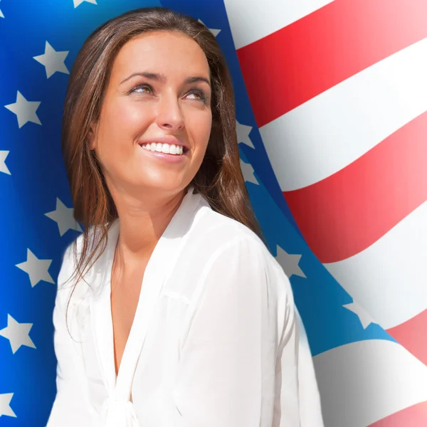 Portrait of a pretty young woman ôïôøòûå an American flag , smil — Φωτογραφία Αρχείου