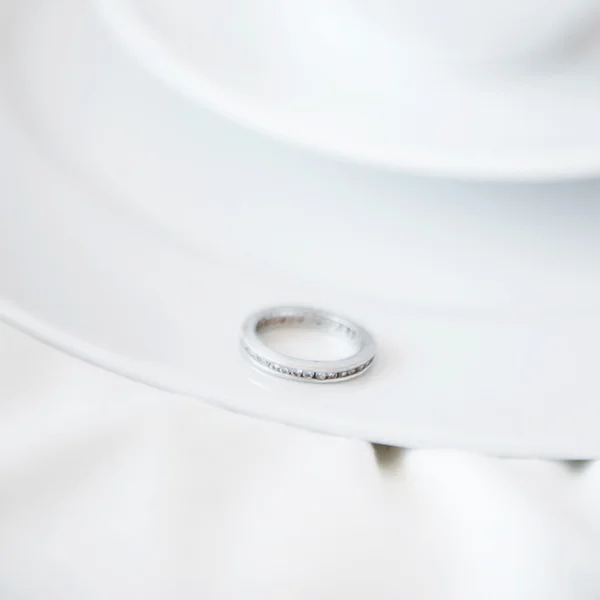 Closeup photo of proposal ring on white plate of coffee cup and — Stock Photo, Image