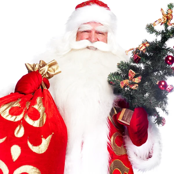 Jultema: Santa Claus håller granen och hans väska full med gif — Stockfoto
