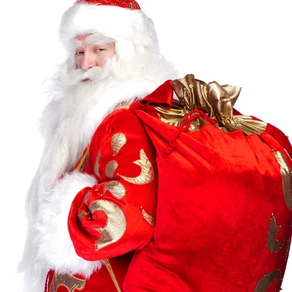 Санта Клаус стоит на белом фоне со своей сумкой, полной — стоковое фото