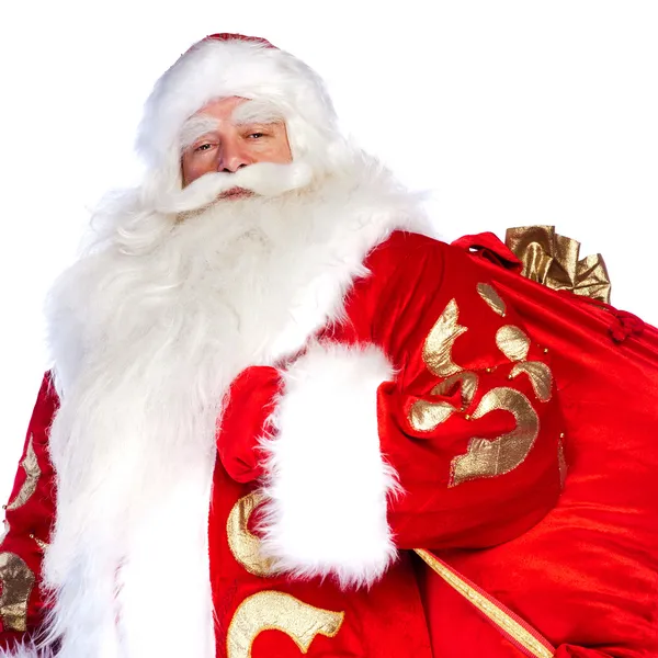 Santa Claus de pie sobre fondo blanco con su bolsa llena de — Foto de Stock