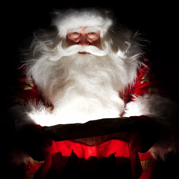 Santa ül a karácsonyi szoba, és vizsgálja a zsák — Stock Fotó