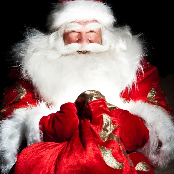 Papai Noel sentado na sala de Natal e olhando para o saco — Fotografia de Stock