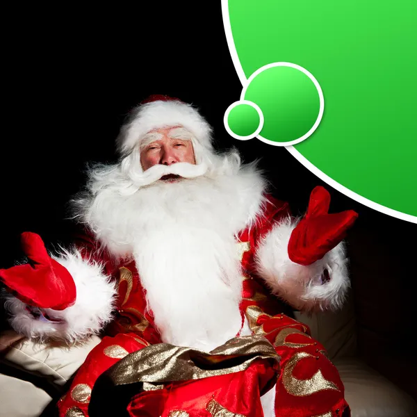 Santa sitter med en säck inomhus på mörka natt rum — Stockfoto