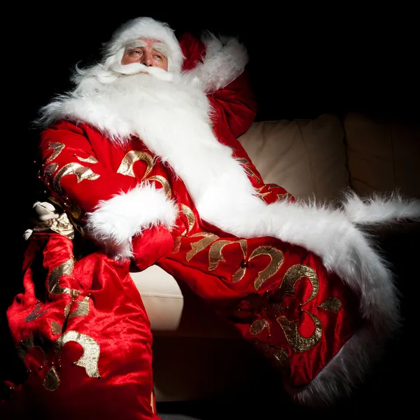 Santa sentado con un saco interior en la sala de noche oscura — Foto de Stock