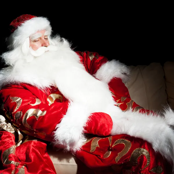 Santa sedí s vnitřní pytel v temné noci pokoj — Stock fotografie