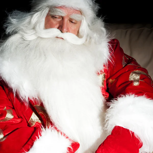 Santa zitten met een zak binnen bij donkere nacht room — Stockfoto
