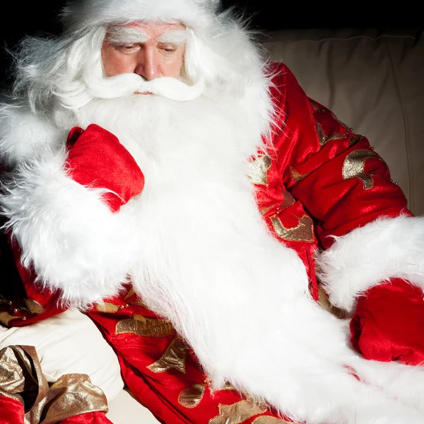 Santa κάθεται με ένα τσουβάλι εσωτερική αίθουσα σκοτεινή νύχτα — Φωτογραφία Αρχείου