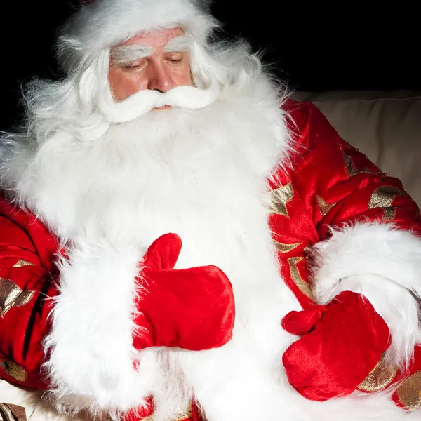 Père Noël assis avec un sac à l'intérieur à la chambre de nuit sombre — Photo