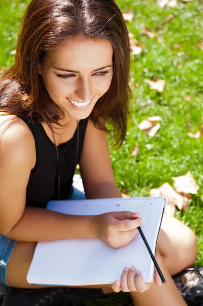 A shot of an caucasian student studying on campus lawn — Stock Photo, Image
