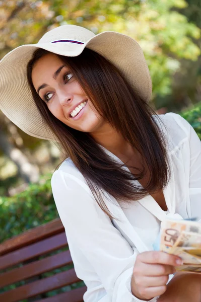 Porträt einer jungen hübschen Frau, die im Sommer oder Winter auf einer Bank sitzt — Stockfoto