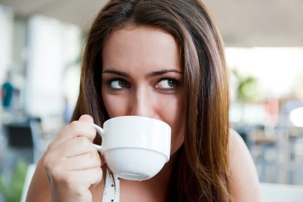 Retrato de cerca de una guapa joven tomando una taza de café — Foto de Stock