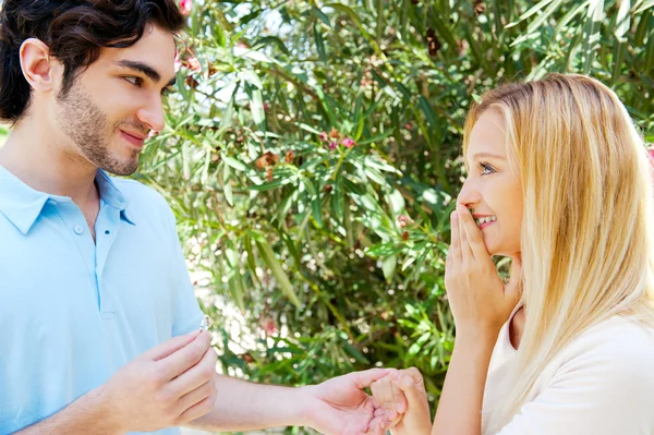 Glücklicher junger hispanischer Mann schenkt einem wunderschönen Überraschungsgast einen Ring — Stockfoto