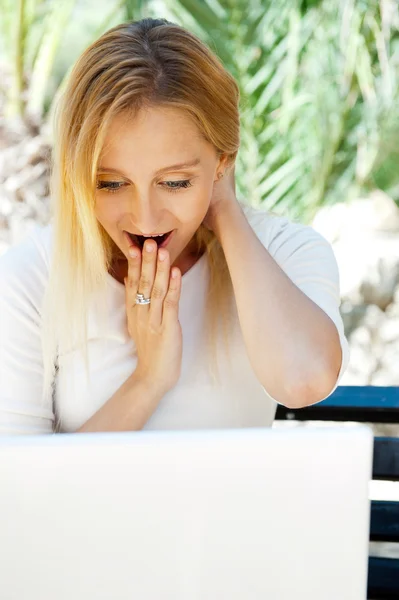 Όμορφη γυναίκα χρησιμοποιώντας φορητό υπολογιστή ενώ κάθεται χαλαρή στον πάγκο σε s — Φωτογραφία Αρχείου