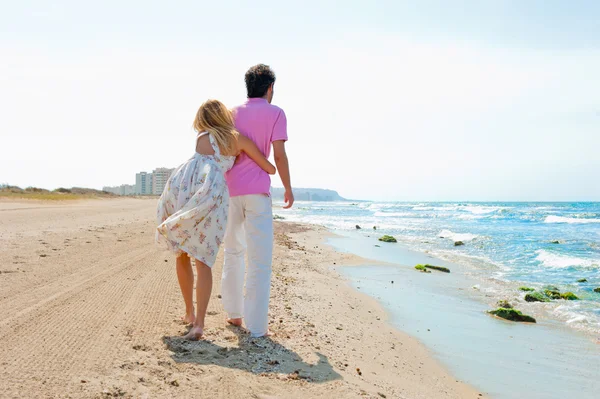 Couple à la plage tenant la main et marchant. Jour ensoleillé, lumineux — Photo