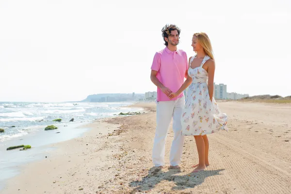 情侣在海滩牵手和行走。阳光灿烂的日子明亮 — 图库照片