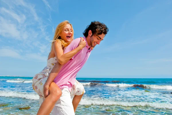 Привлекательная пара валяет дурака на пляже — стоковое фото