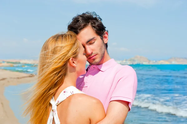 Portrait of young couple in love embracing at beach and enjoying — Stock Photo, Image