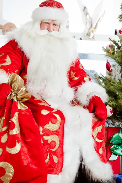 Santa sentado na árvore de Natal, lareira e olhando para ca — Fotografia de Stock