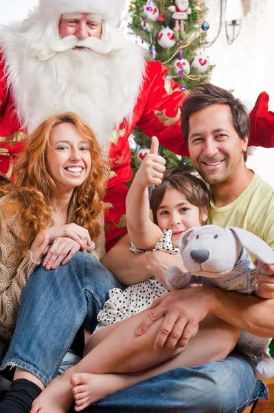 快乐家庭拥抱和坐在圣诞前面的地板上 — 图库照片