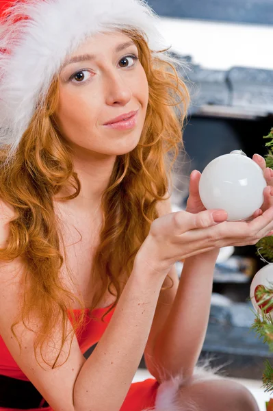 Jul kvinna nära en julgran håller jul leksak whil — Stockfoto