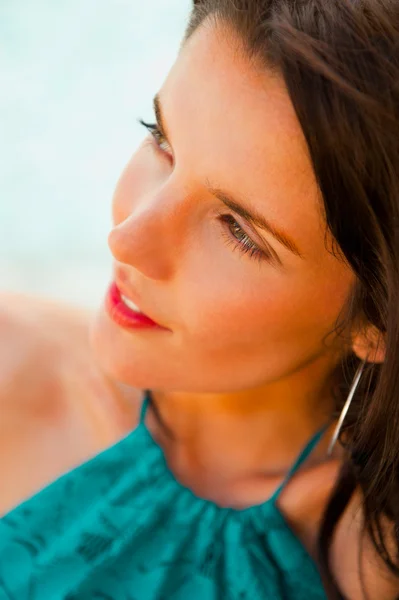 Genç ve güzel kadın ile sıcak bakmak ve gülümsemek kumsalda oturuyor — Stok fotoğraf