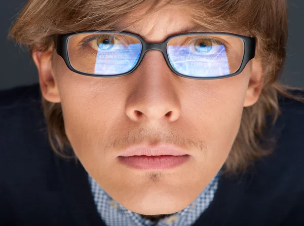 Satisfied young man with glasses looking at camera like at lapto — Stock Photo, Image