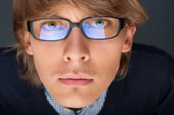 Satisfied young man with glasses looking at camera like at lapto — Stock Photo, Image