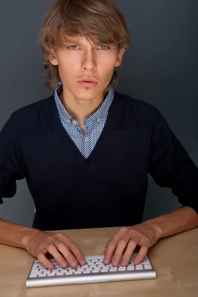 Portrét mladého hezký dobrý vyhlížející muž pracuje, používat klávesnici šip — Stock fotografie