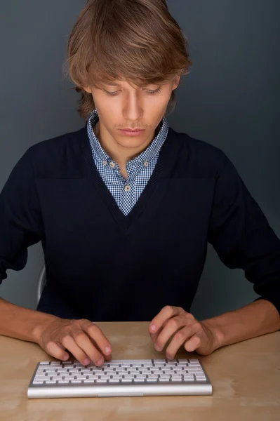 Portrét mladého hezký dobrý vyhlížející muž pracuje, používat klávesnici šip — Stock fotografie