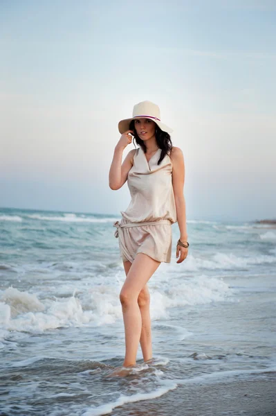 Smiling young woman wearing a straw hat and having fun at the be — Stock Photo, Image