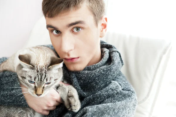 Uomo rilassato seduto sulla poltrona tenendo e accarezzando gatto domestico — Foto Stock