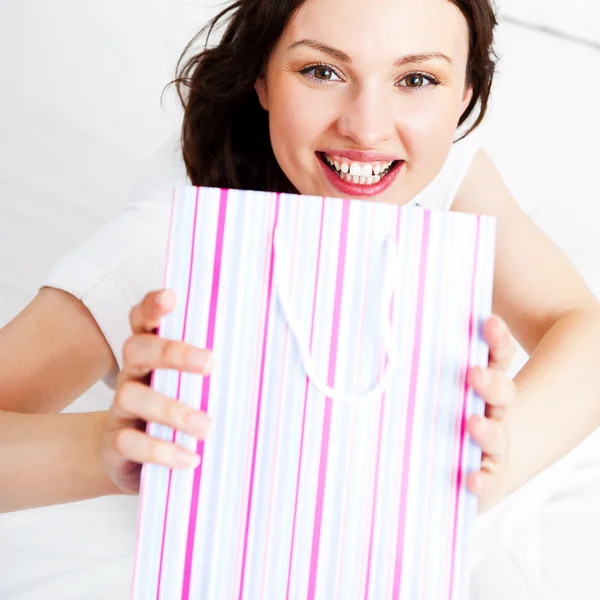 Portrait of young beautiful awake woman with gifts on bed at bed Royalty Free Stock Images