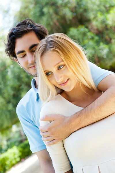 Portrait of love couple embracing outdoor in park looking happy Stock Image