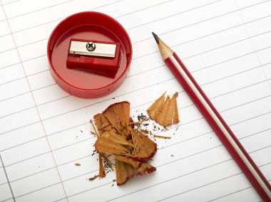 Sharpened pencil next to the sharpener and shavings. clipart