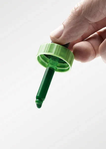 緑色のインク eyerdropper を持っている人間の手 — ストック写真