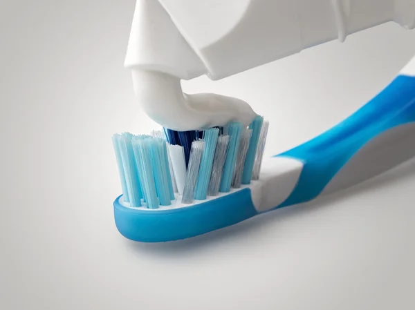 Fechar a pasta de dentes que sai de um tubo — Fotografia de Stock
