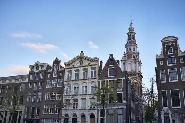 Holanda, Ámsterdam, antiguas casas de piedra y un campanario de la catedral —  Fotos de Stock
