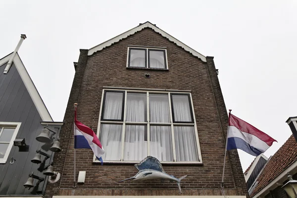 Hollande, Volendam, vieille maison en pierre et drapeaux hollandais — Photo