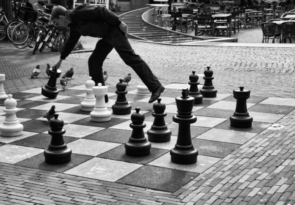Голландия, Амстердам, мужчина, играющий в шахматы на центральной улице — стоковое фото